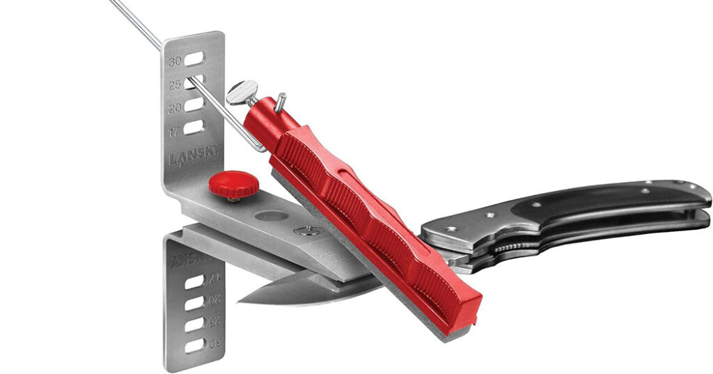 Lansky knife sharpener with the red / coarse tool attached being used to polish a lock knife blade. 